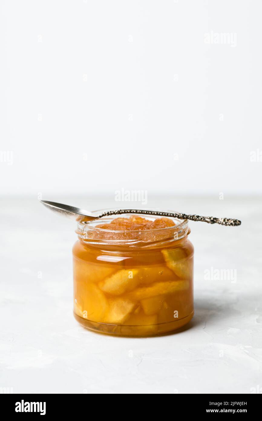 Apple jam in a jar with a spoon on a white background Stock Photo