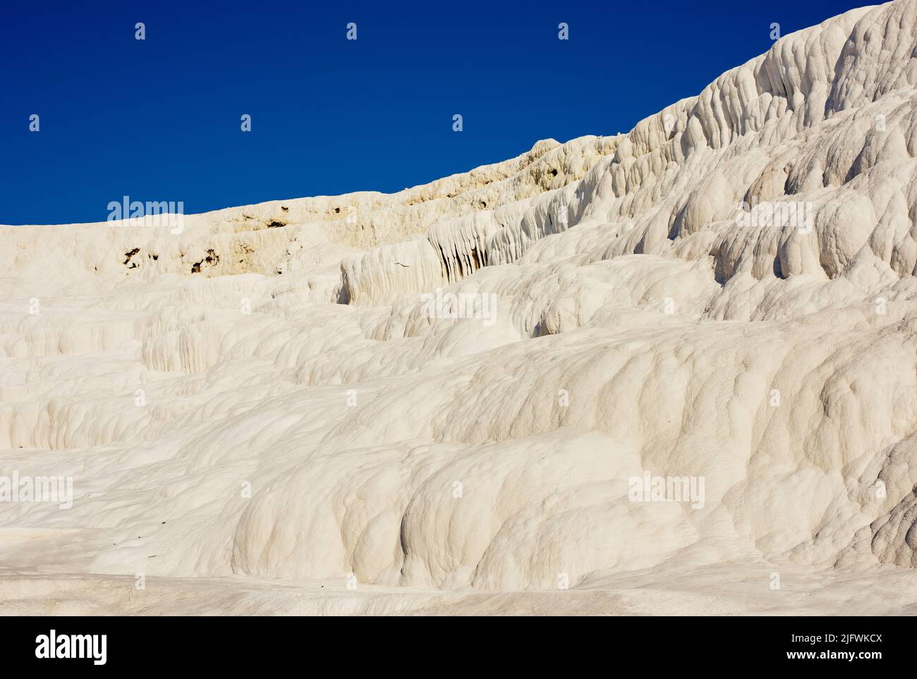 Scenic view of travertine pools and terraces in Pamukkale, Turkey. Traveling abroad, overseas for vacation and tourism. Cotton castle area with a Stock Photo