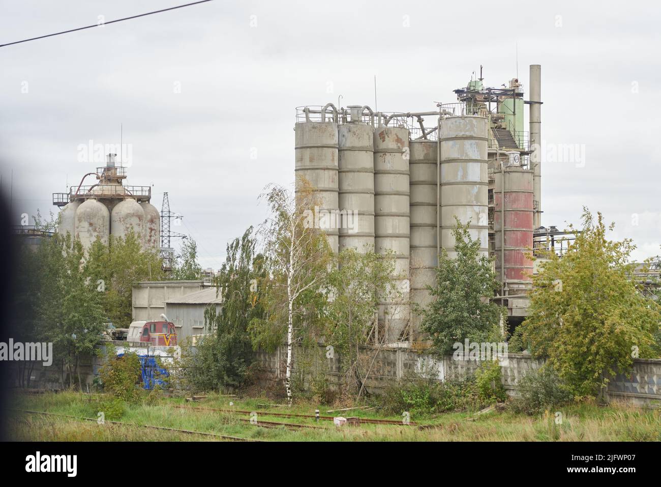 Cement bunkers (silos) in autumn day among the trees Stock Photo