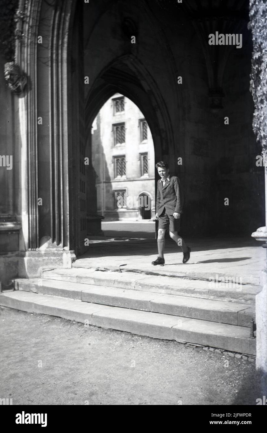 1950s, historical, a schoolboy walking though the covered entrance at Kings College, one of the many ancient colleges that make up the University of Cambridge, England, UK. It was founded in 1441 by Henry VI of England, shortly after he had established another famous English instution, Eton College. Kings College is known as one of the finest examples of late English Gothic Architecture. Stock Photo