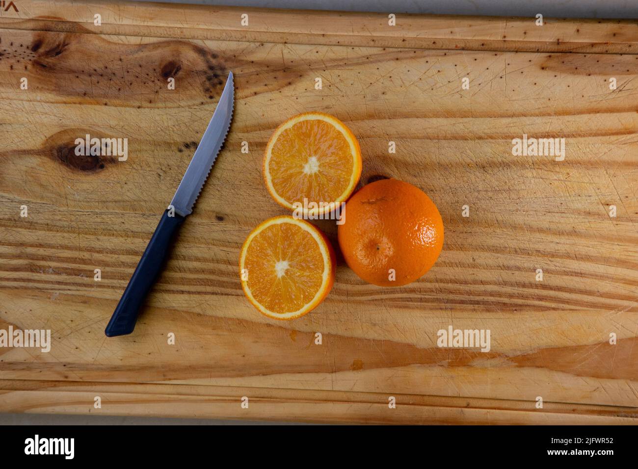 Oranges cut in half to make fresh juice on a wooden table. Stock Photo