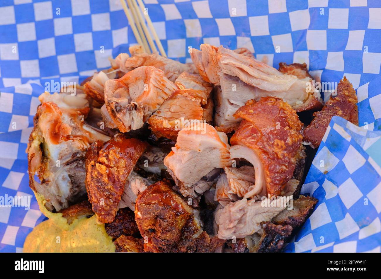 Pork Hock in Paper Basket with skewers and mustard Stock Photo