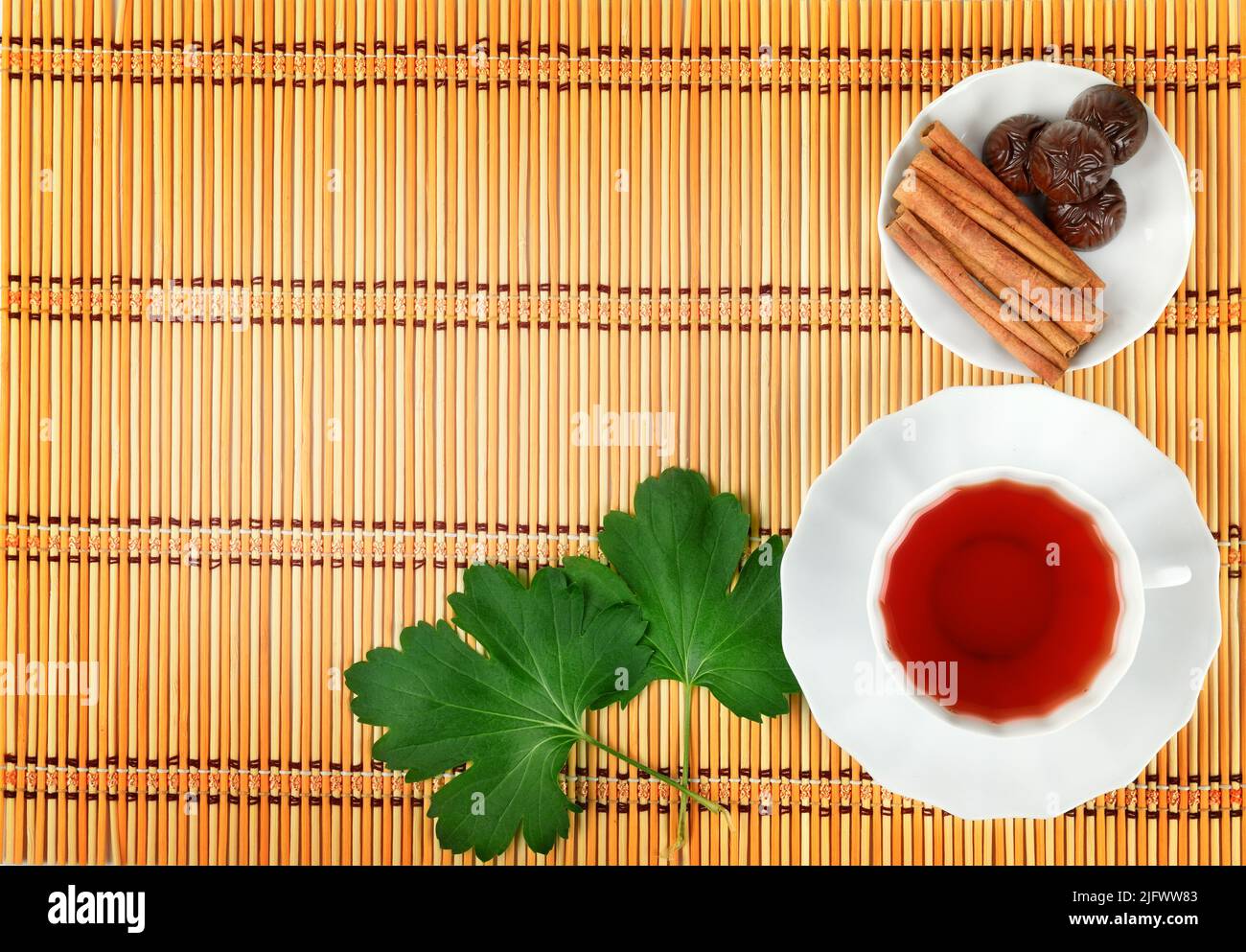 Hot tea with spices on a bamboo mat background Stock Photo