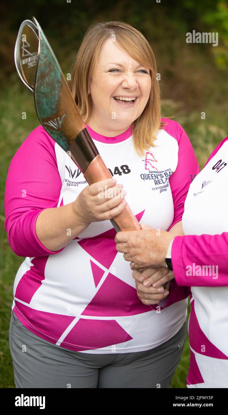A Baton Bearer holds The Queen’s Baton during a visit from the