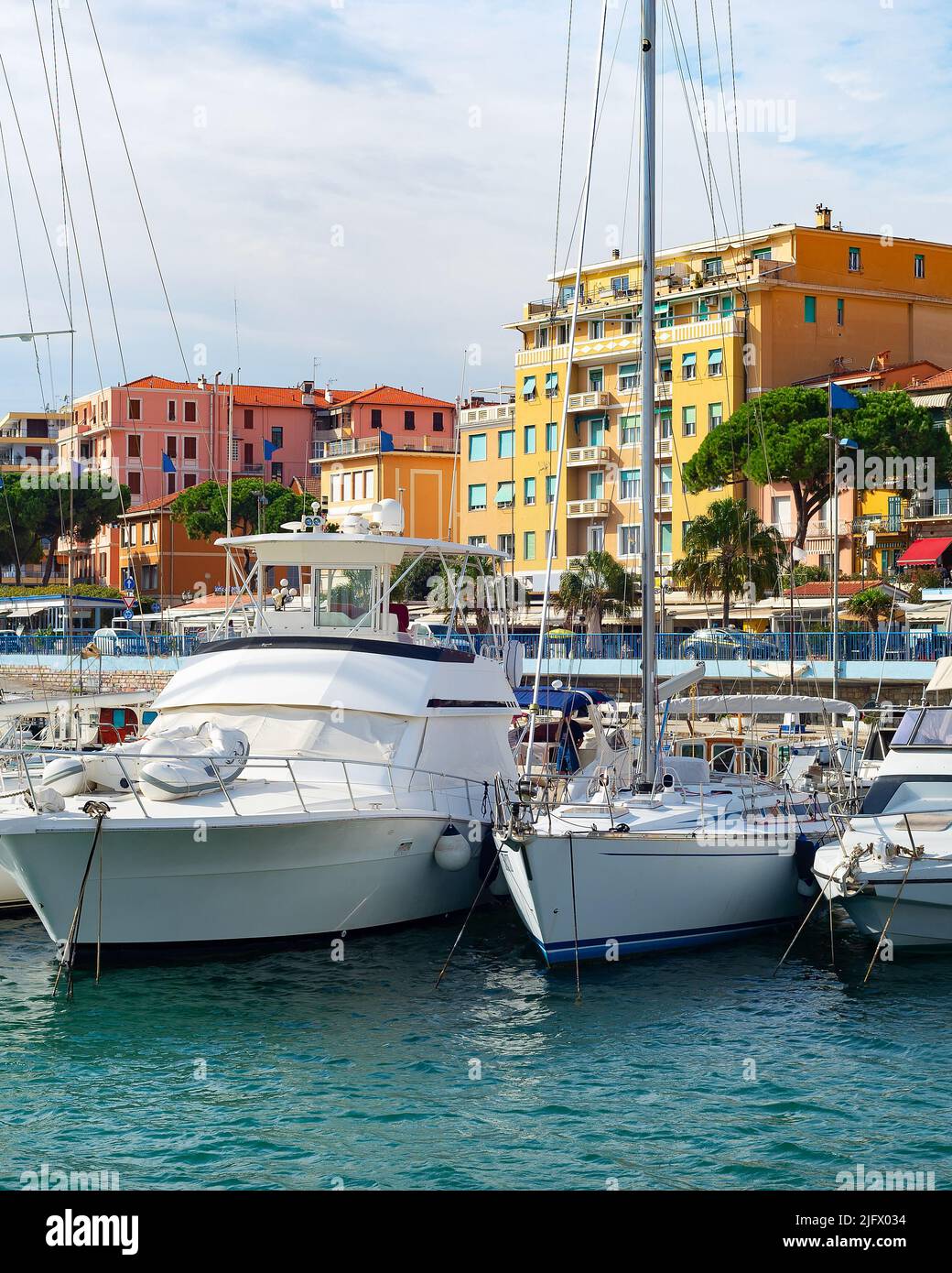 Marina with yachts in bright sunhine, cityscape in background, Sanremo, Itlay Stock Photo