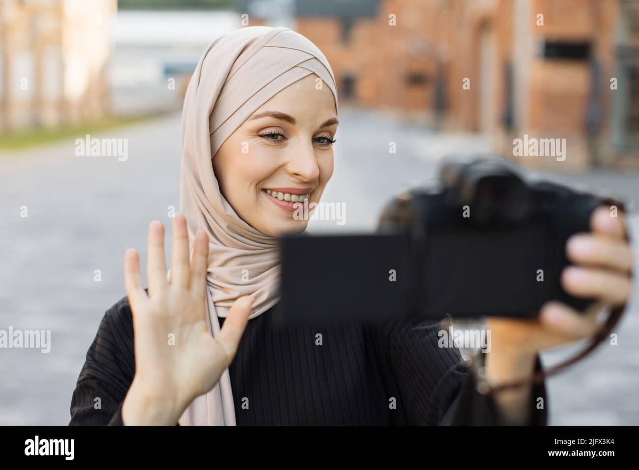 Young muslim woman using a video camera to record journey with smile ...