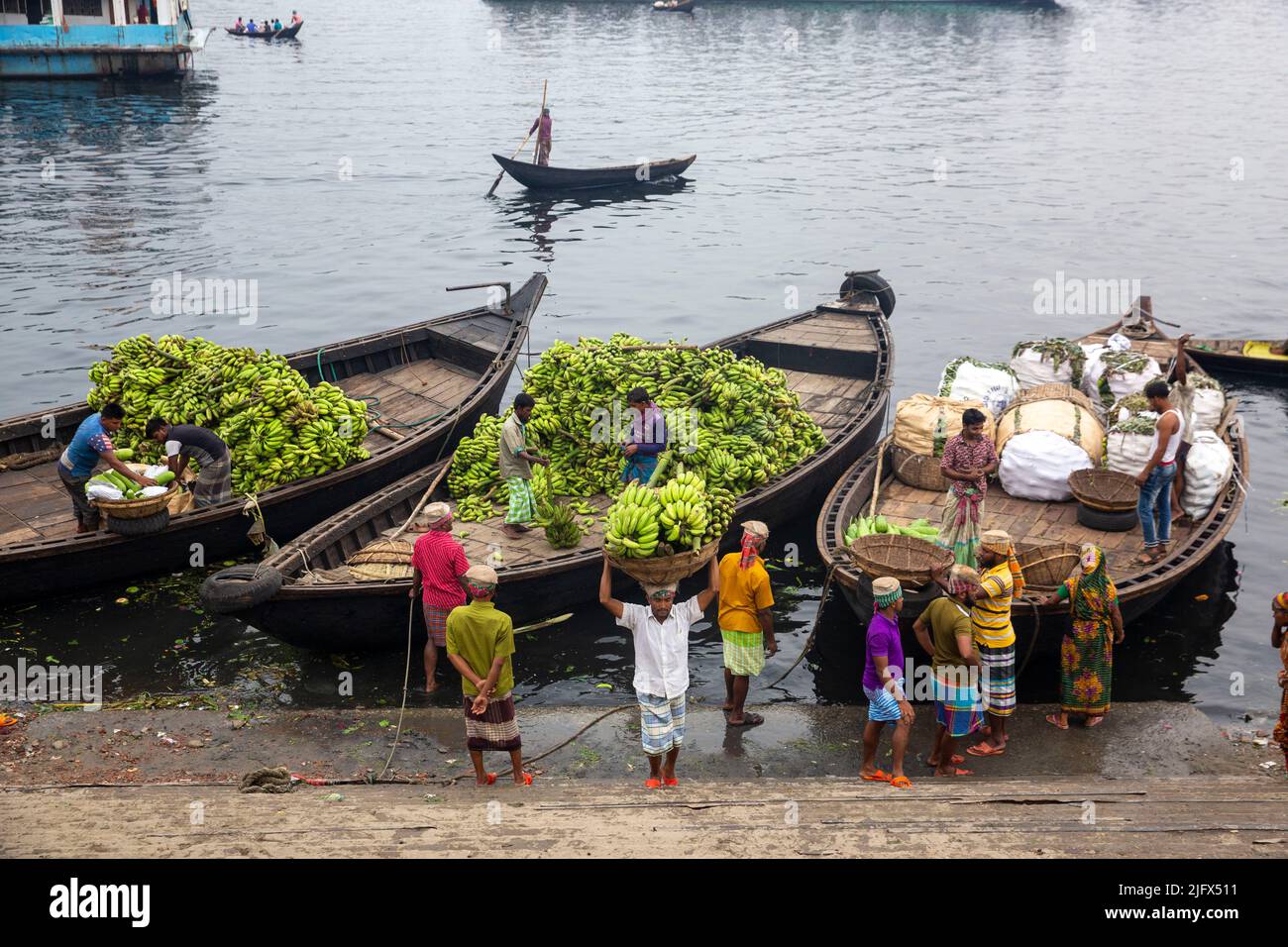 Workers are busy offloading seasonal fruits from boats at Wiseghat in Old Dhaka. Bangladesh Stock Photo