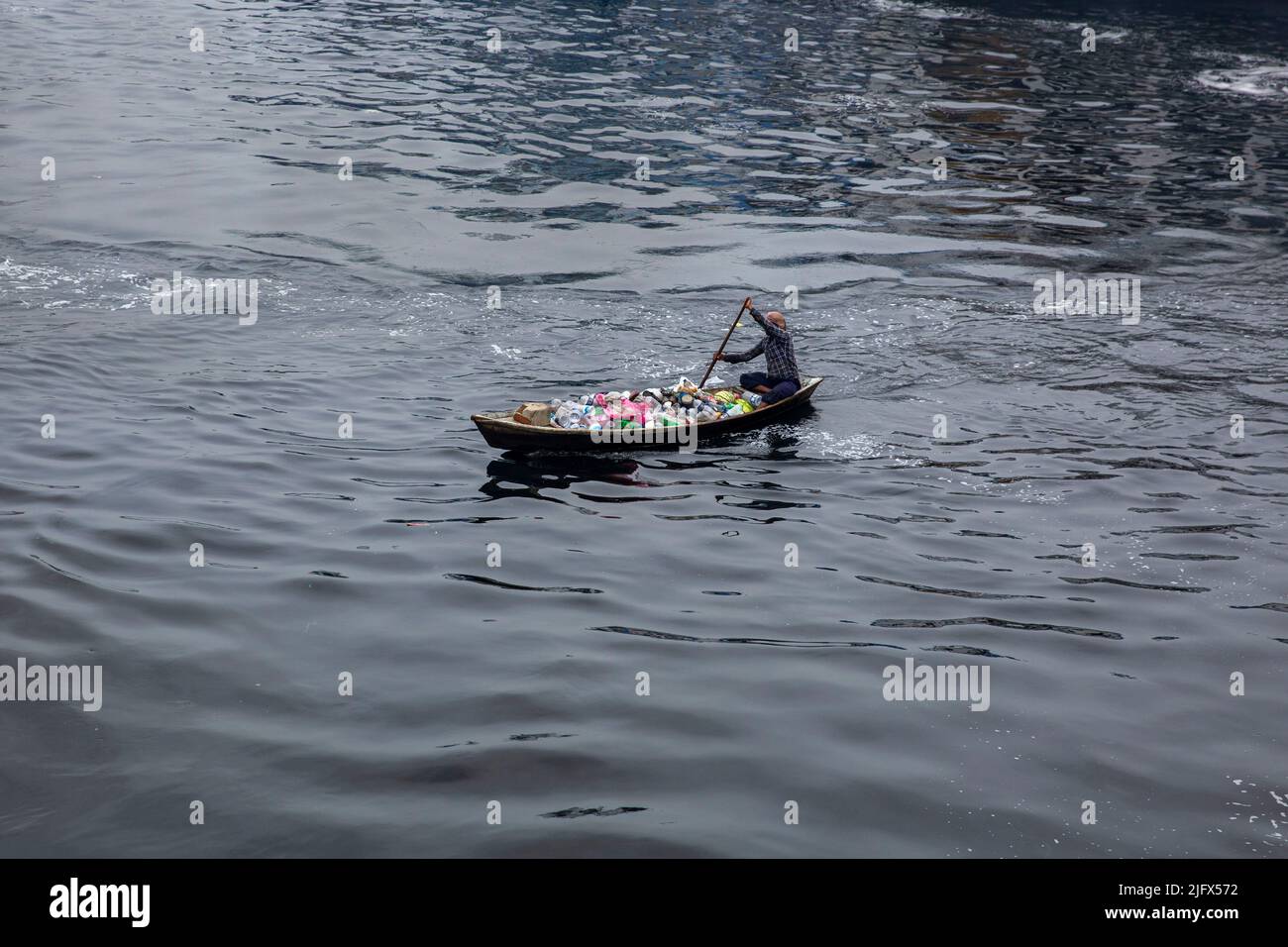 A man collects plastic waste form Buriganga River, Dhaka, Bangladesh Stock Photo