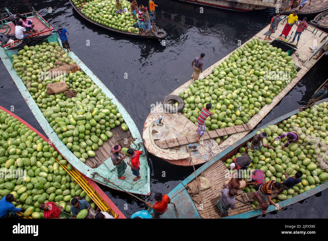 Boats packed with watermelons anchored Dhaka's Badamtali Fruit Market terminal, later than usual, increasing supplies. Dhaka, Bangladesh Stock Photo