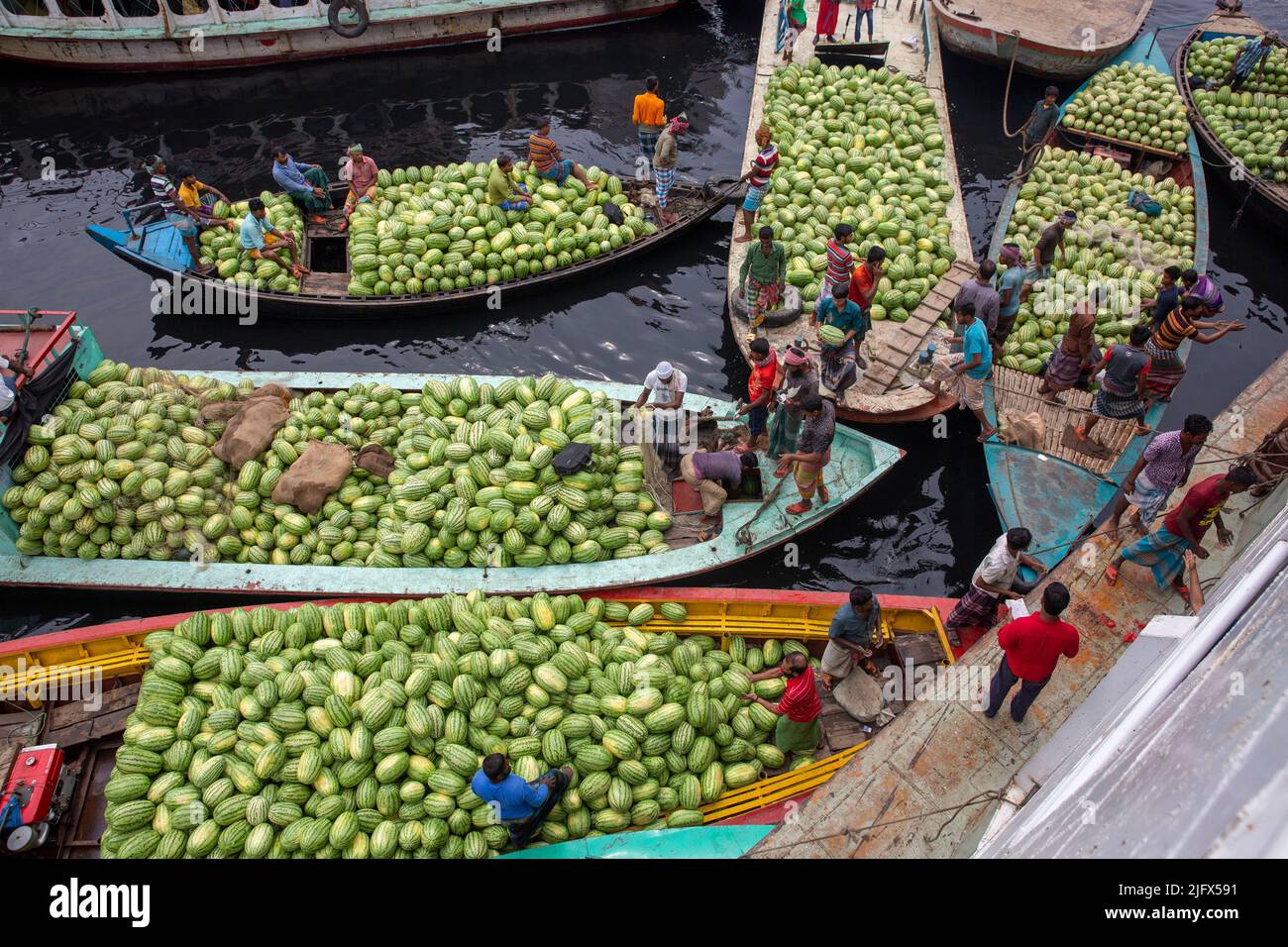 Boats packed with watermelons anchored Dhaka's Badamtali Fruit Market terminal, later than usual, increasing supplies. Dhaka, Bangladesh Stock Photo