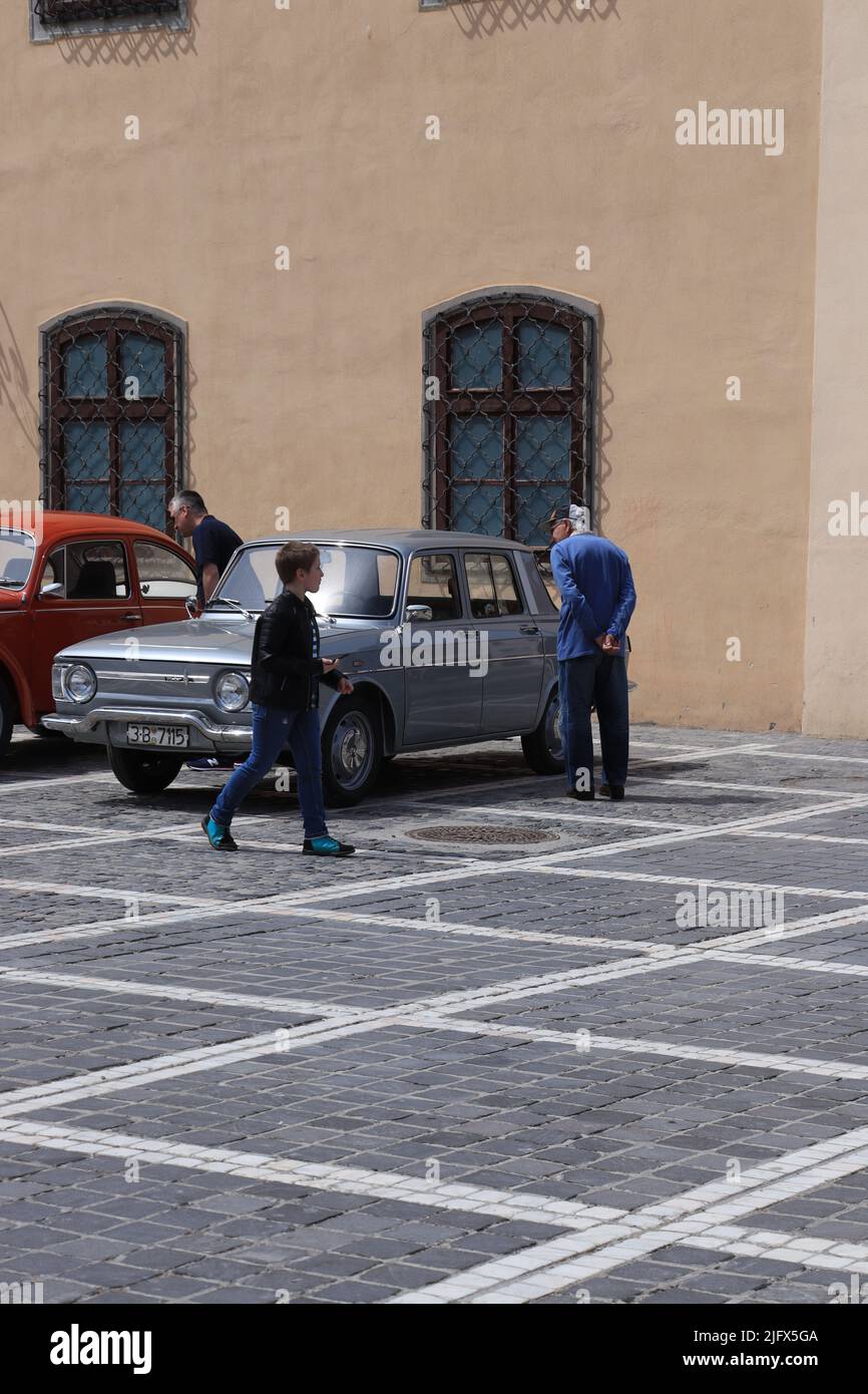 People admiring an old car at a local car fair in Brasov Stock Photo