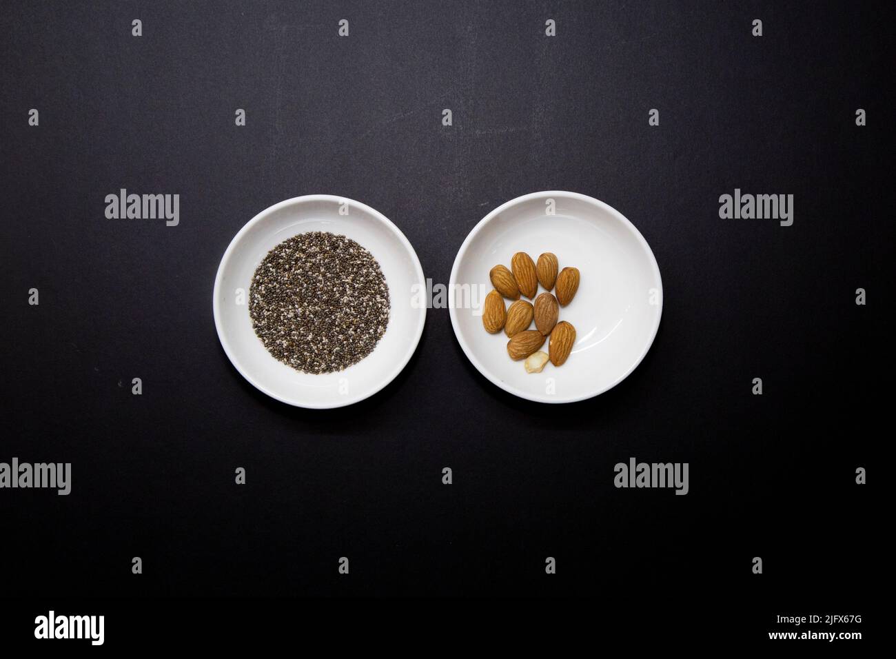 Healthy food in two round white porcelain bowls on a black background Stock Photo Alamy