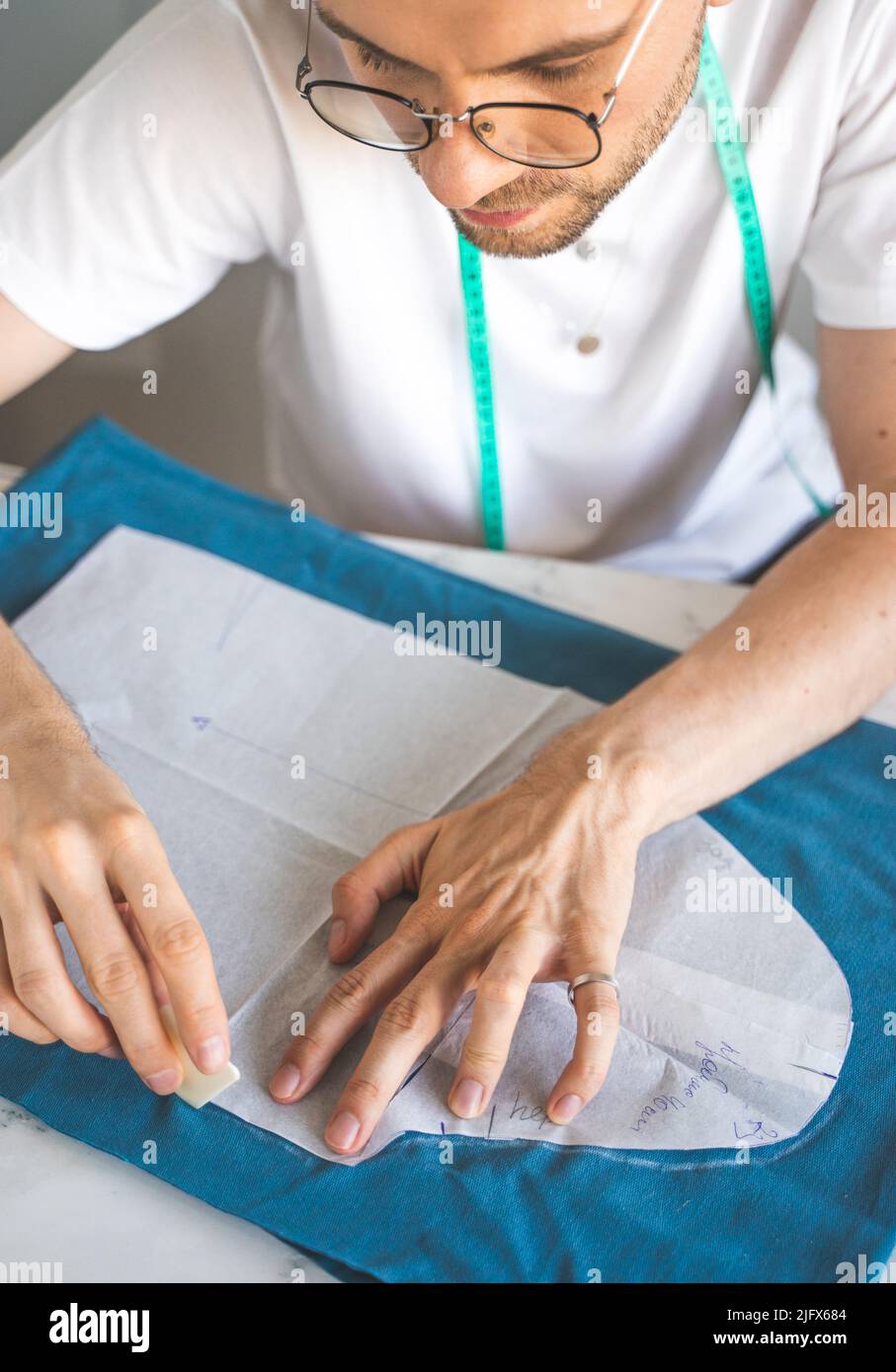 Seamster Patterns A self-taught seamster in white t-shirt and glasses works with fabric ...