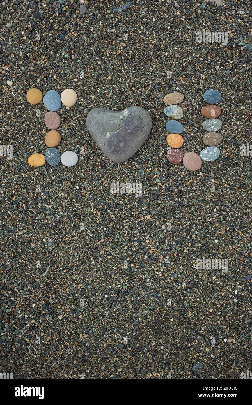 I love U made from stones on sandy beach. Romantic mood during vacation. Stock Photo