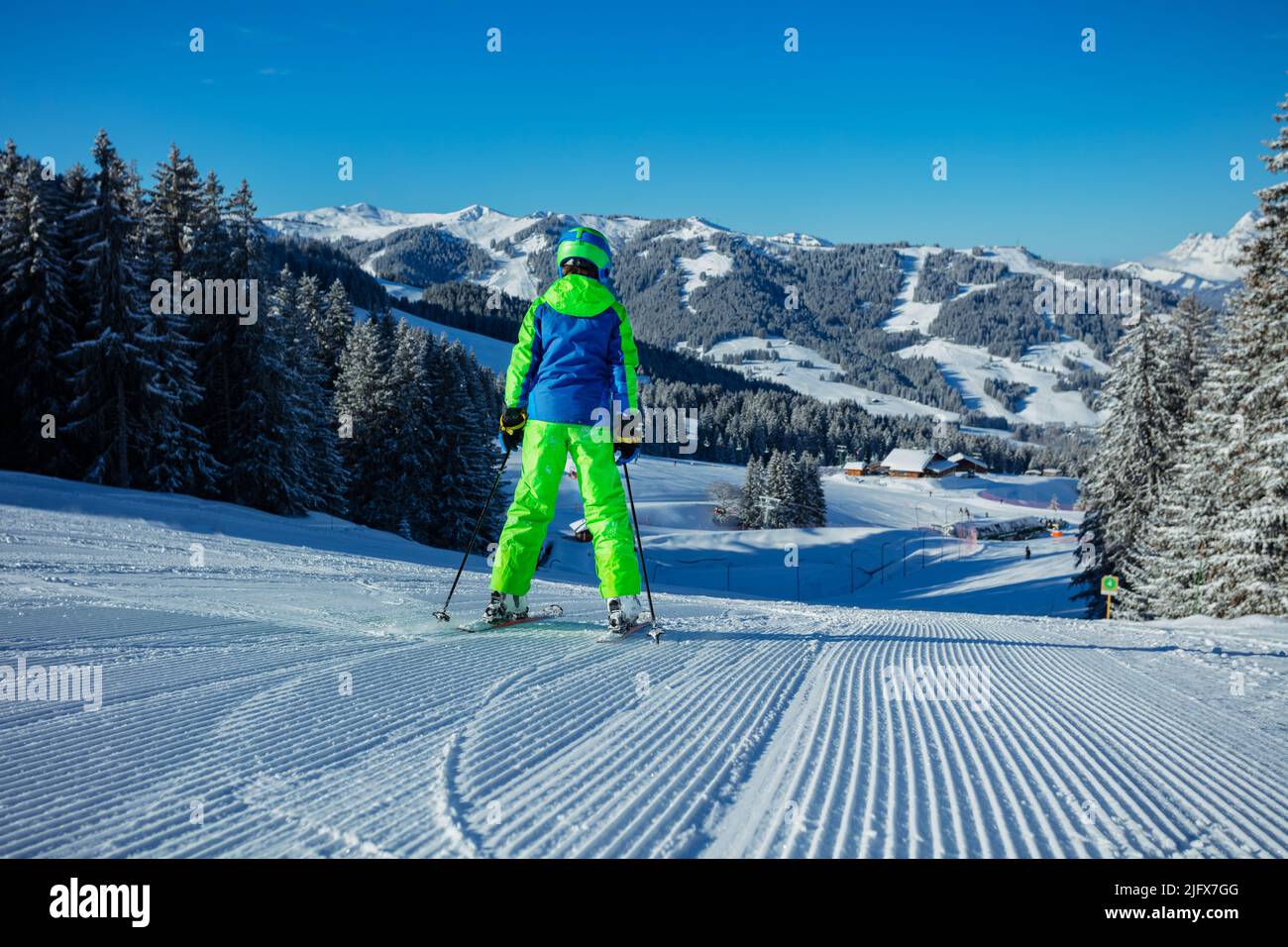 Back view of a boy alpine ski downhill on the fresh track Stock Photo
