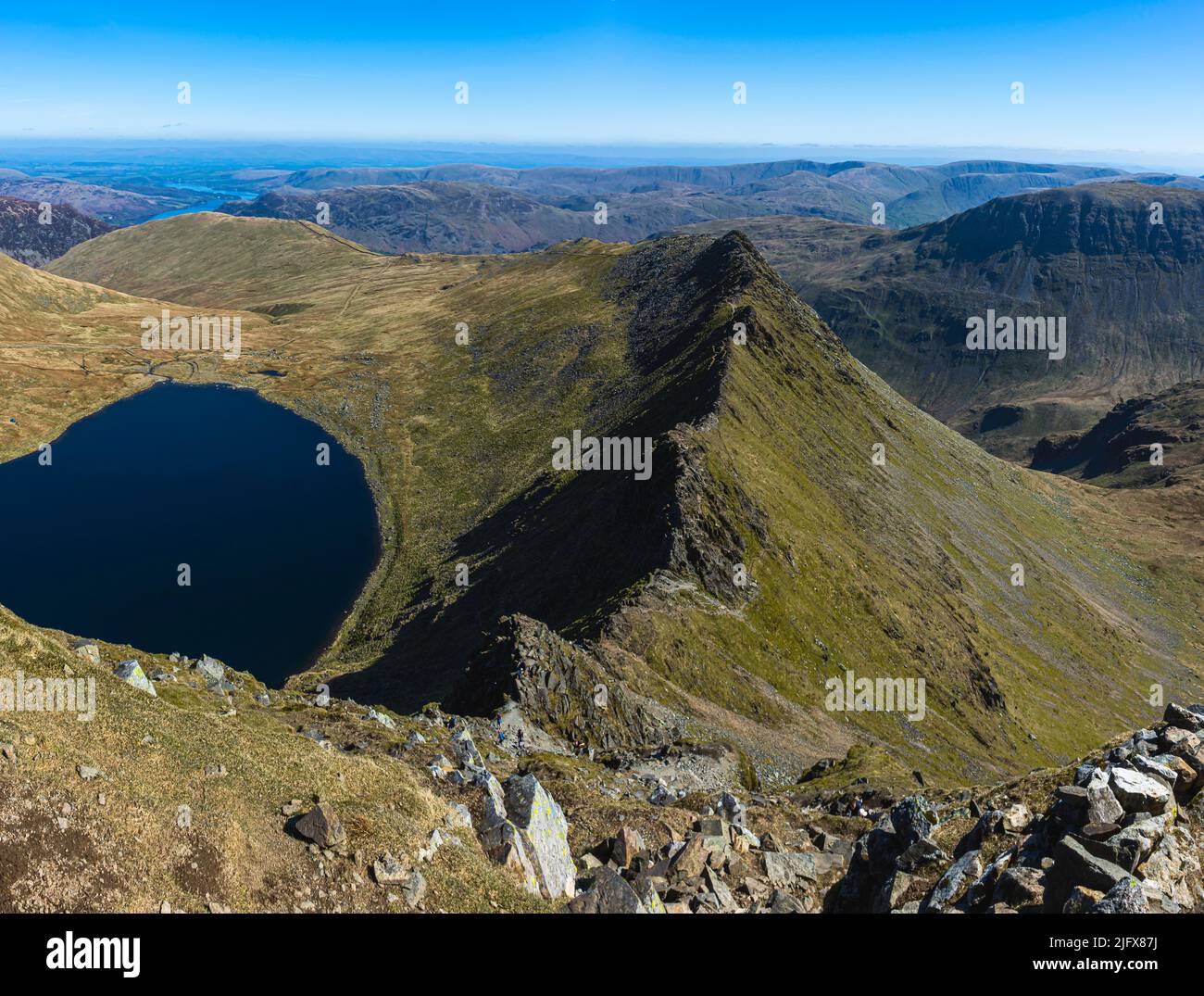 Striding Edge and Red Tarn. View from Helvellyn on beautiful day with clear blue sky. Beautiful landscape scenery in Lake District, Cumria, UK. Stock Photo