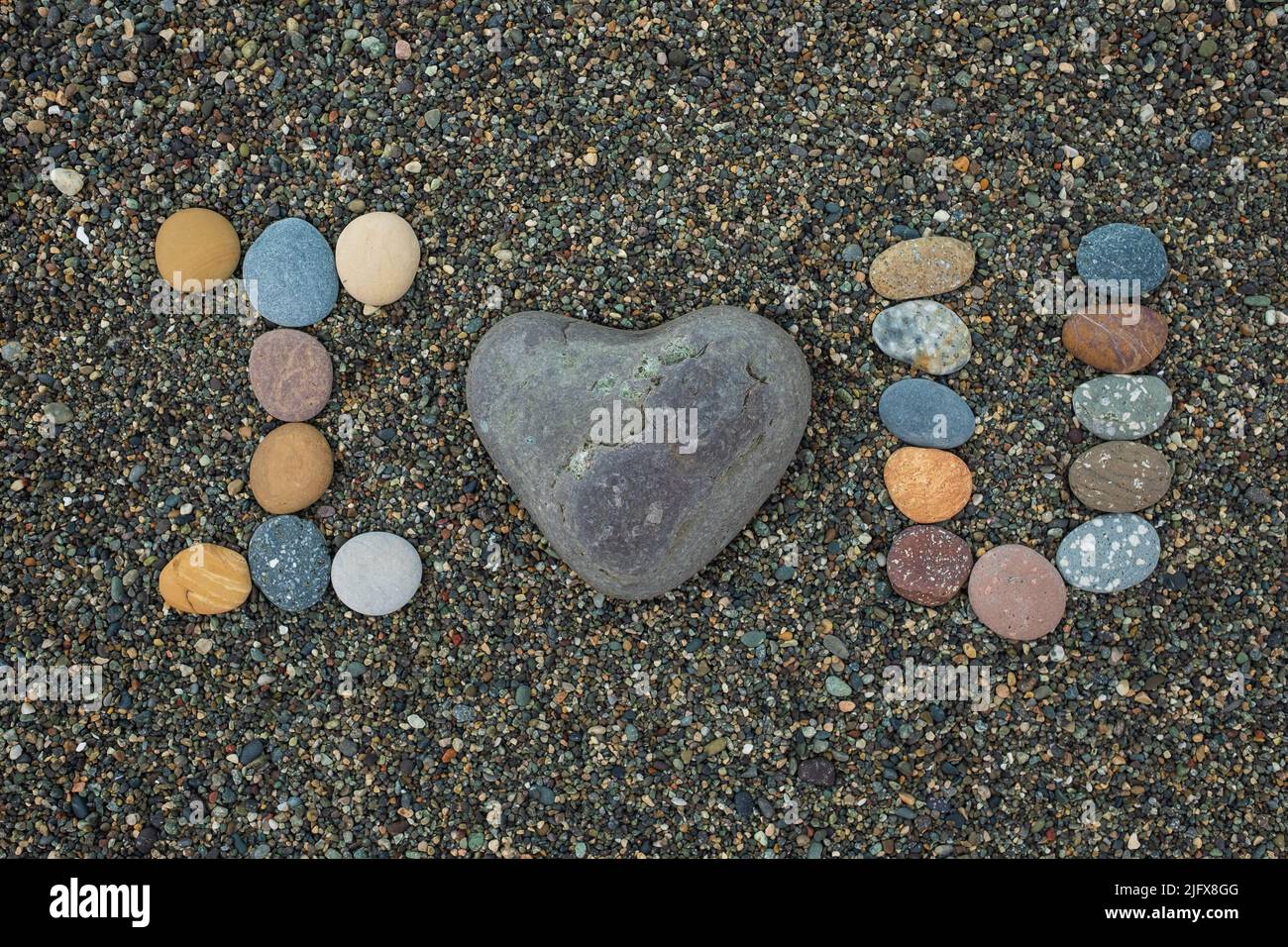 I love U made from stones on sandy beach. Romantic mood during vacation. Stock Photo