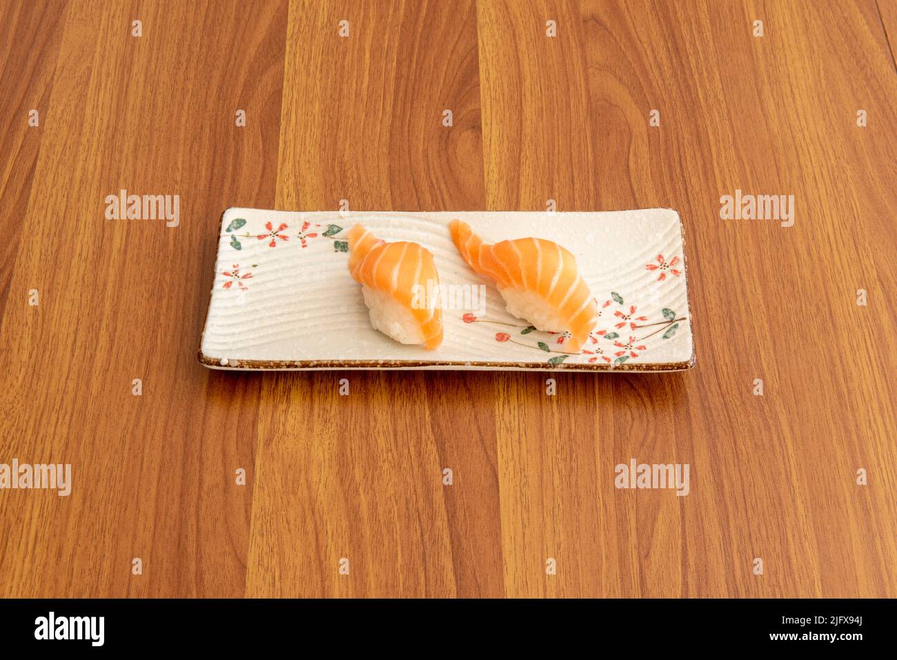 Norwegian salmon nigiri portion with Japanese rice on rectangular white ...