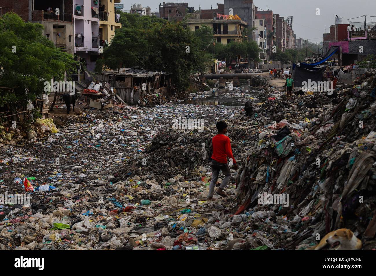 View of an open dump area filled with plastic and garbage at a slum area in New Delhi. In order to prevent its harmful effects on the environment and in pursuance of its global climate goals, India will ban the use of single-use plastics from July 1st 2022. Stock Photo