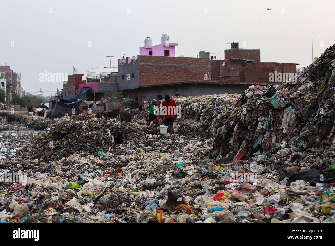 View of an open dump area filled with plastic and garbage at a slum area in New Delhi. In order to prevent its harmful effects on the environment and in pursuance of its global climate goals, India will ban the use of single-use plastics from July 1st 2022. Stock Photo
