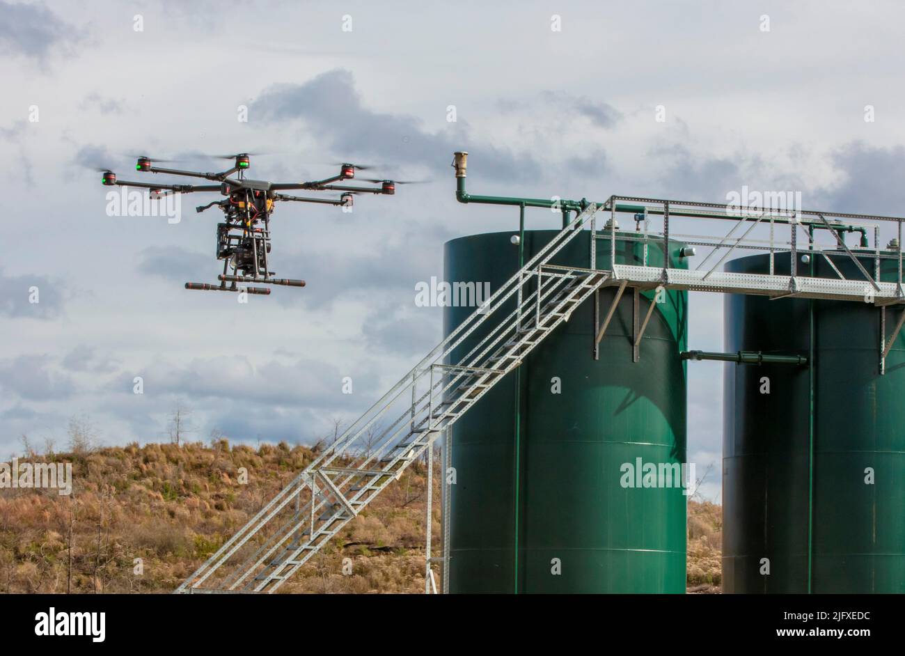 Drone inspects for methane leaks on well site Stock Photo