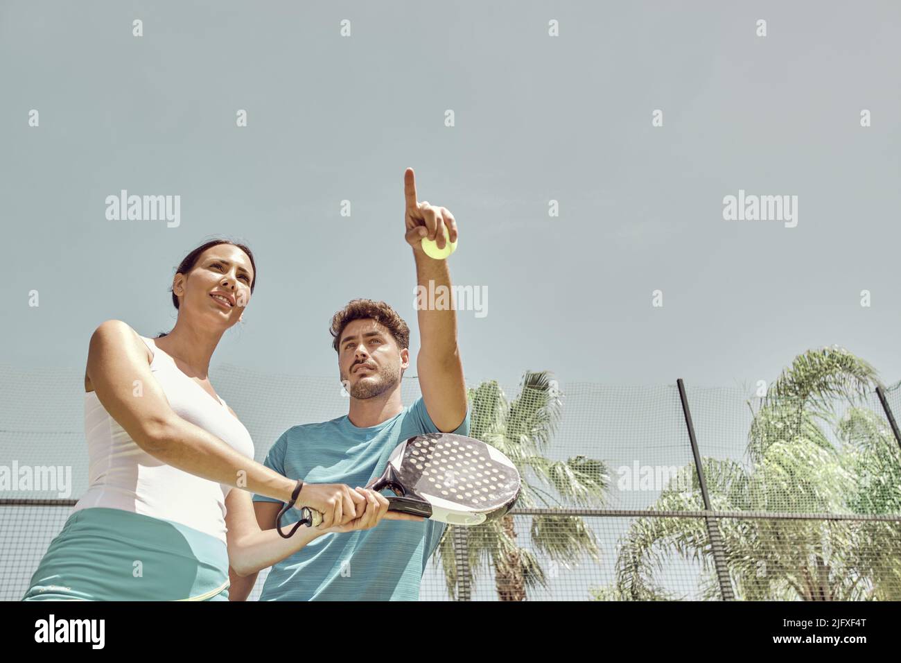 Monitor giving paddle tennis classes to a woman, his student Stock Photo Alamy