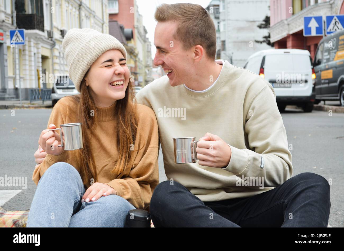 A couple in love id sitting on the road and drinking some tea Stock Photo