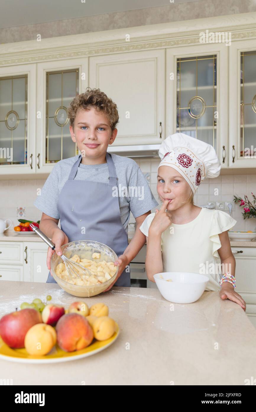 Children in the kitchen are preparing an apple pie. Stock Photo