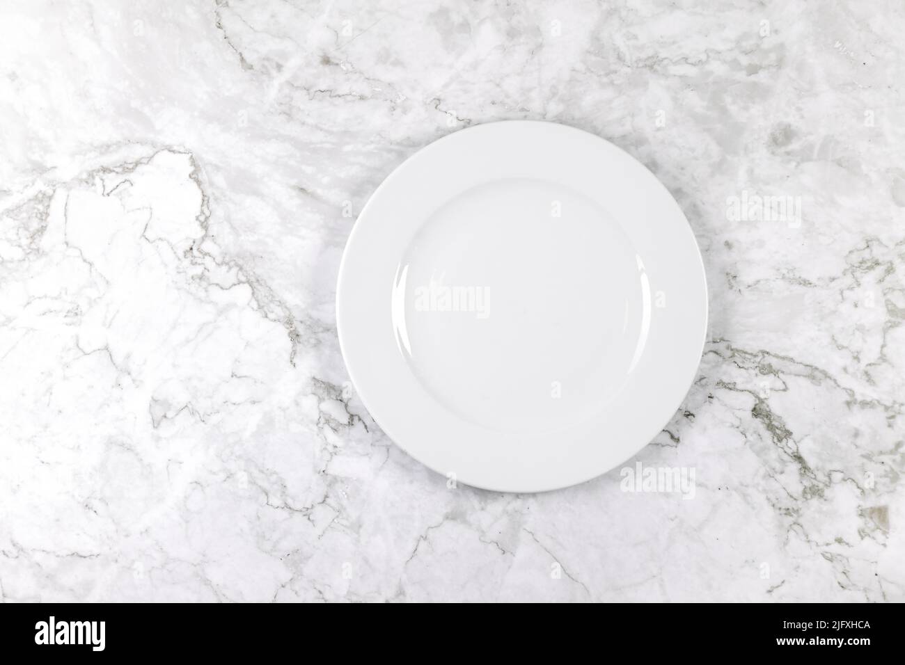 Dinner plate on a white and grey marble surface Stock Photo