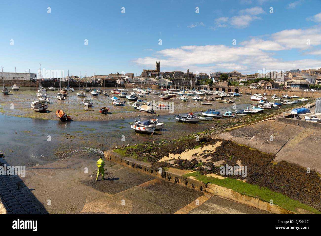 Penzance, Cornwall, England, UK. 2022. Man using a pressure washer at
