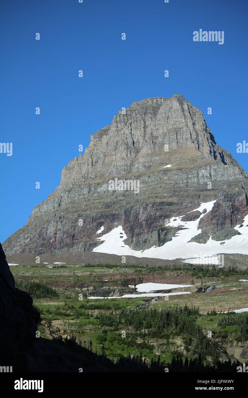 Glacier National Park Montana USA - Logan Pass, Going to the Sun Road, brilliant blue sky, majestic Clements Mountain peak, melting snow waterfalls Stock Photo