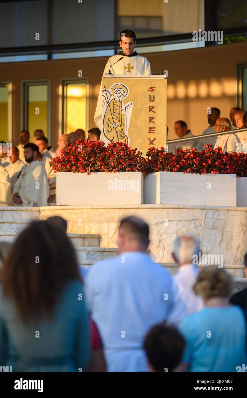A young priest reading the Gospel during the evening Holy Mass in Medjugorje on 4 September 2021. Stock Photo