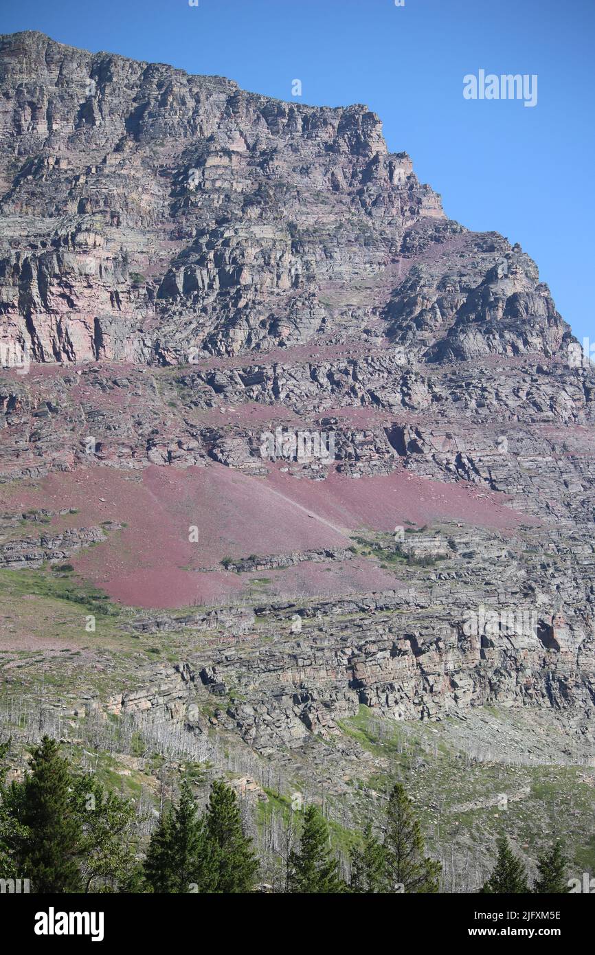 Colorful red & golden banded Belt series sedimentary argillite & limestone visible on sheer cliffs of Goat Mountain, Glacier National Park, MT, USA Stock Photo