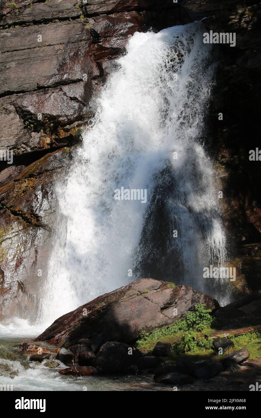 Full classic view, white cascading pristine water over red rock cliff, Baring Falls, St. Mary Lake, Going to the Sun Rd, Glacier National Park, MT, US Stock Photo