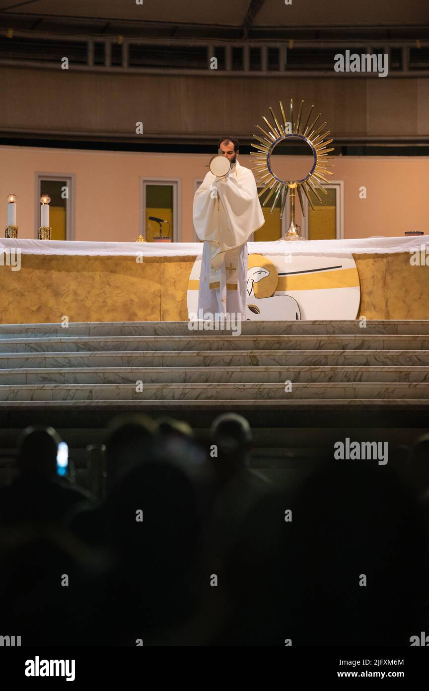 A priest blessing the faithful with the Blessed Sacrament at the conclusion of a Eucharistic adoration in Medjugorje, Bosnia and Herzegovina. Stock Photo