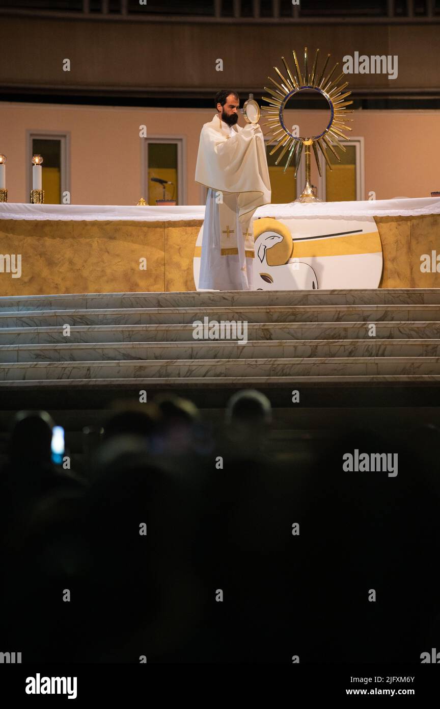A priest blessing the faithful with the Blessed Sacrament at the conclusion of a Eucharistic adoration in Medjugorje, Bosnia and Herzegovina. Stock Photo
