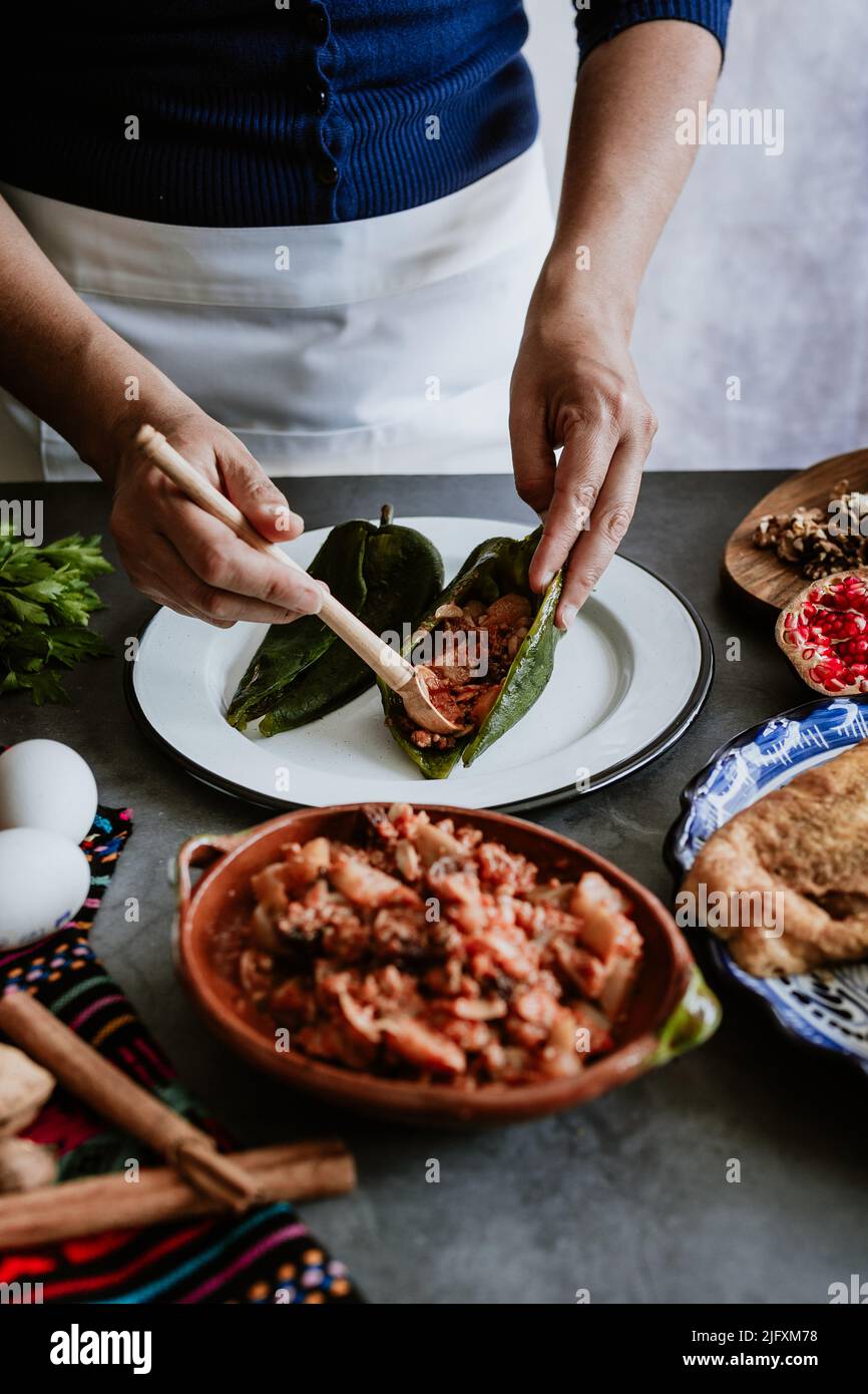 mexican woman cooking chiles en nogada recipe with Poblano chili and ...