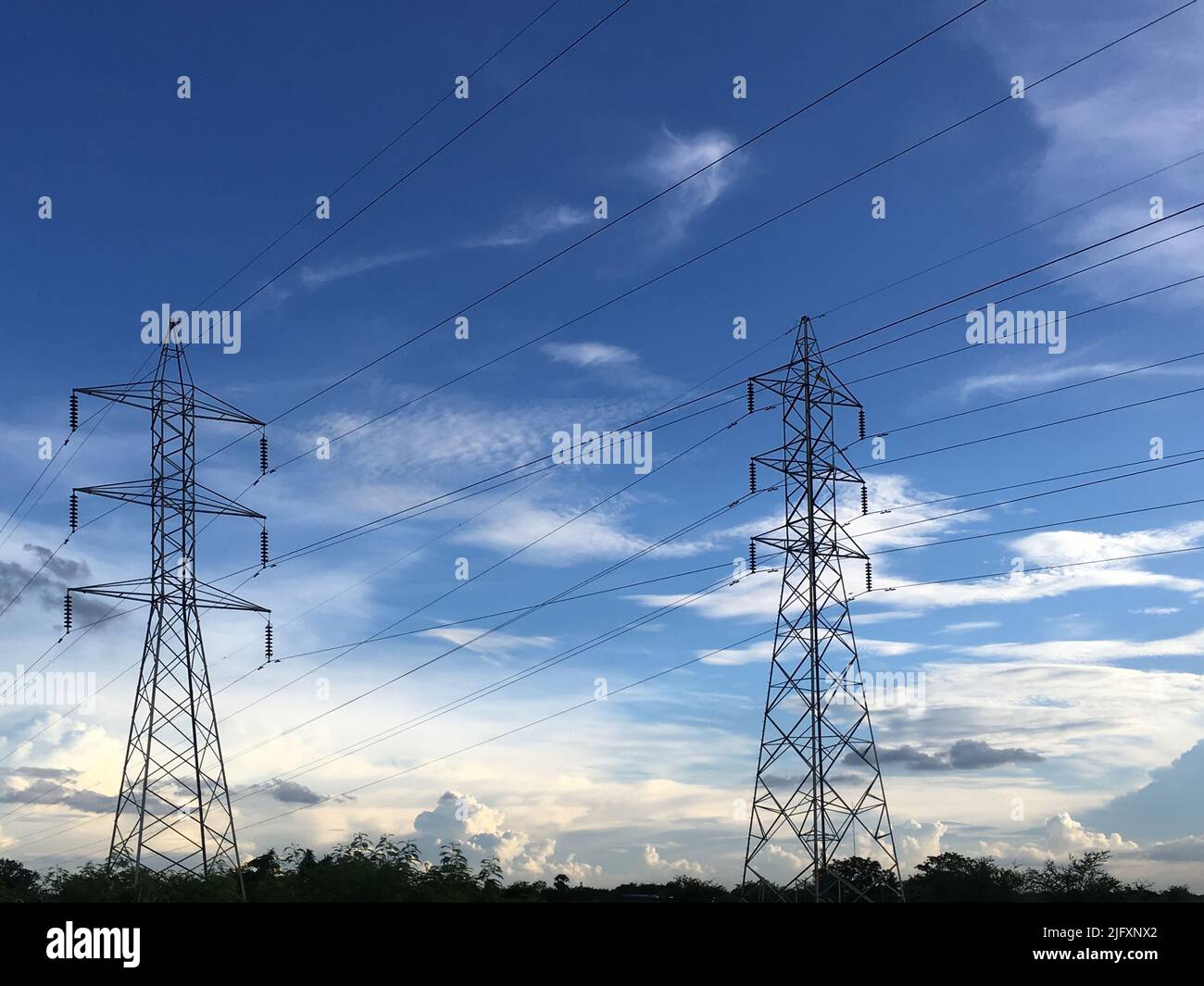 Electricity pylons with a cloudy sky Stock Photo - Alamy
