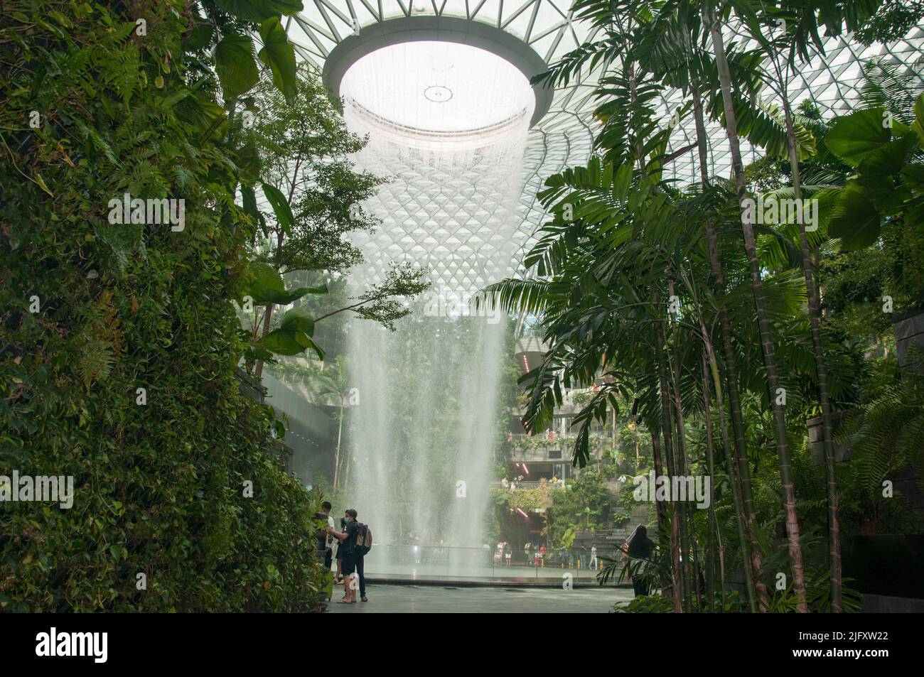 Standing 40 metres tall with water cascading down from the roof of Jewel at Changi Airport, HSBC Rain Vortex is the world’s tallest indoor waterfall Stock Photo