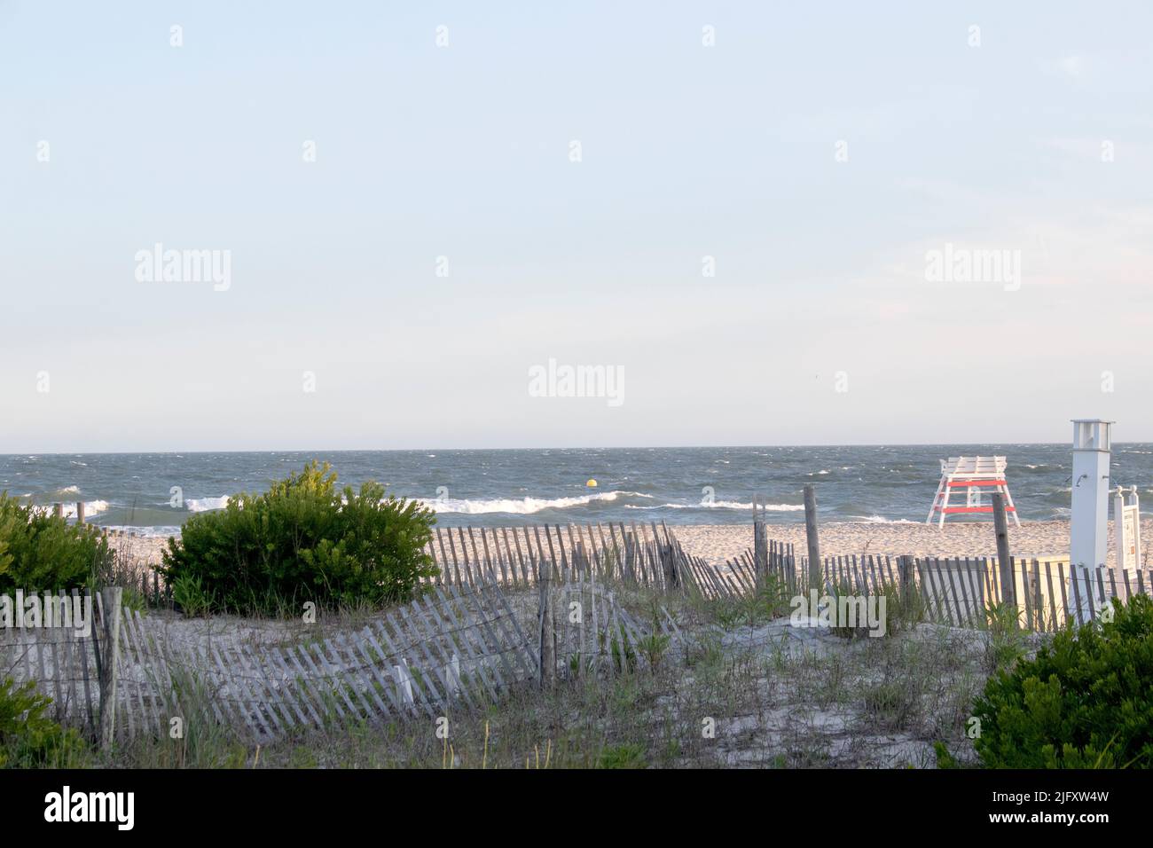 Rustic Picket fence lines the beautiful sand dunes of the ocean and