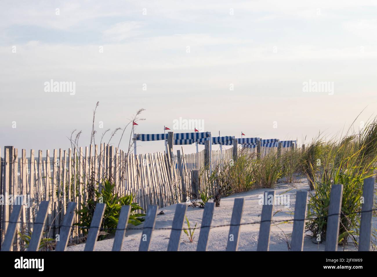 Rustic Picket fence lines the beautiful sand dunes of the ocean and beach of Cape May New Jersey Stock Photo