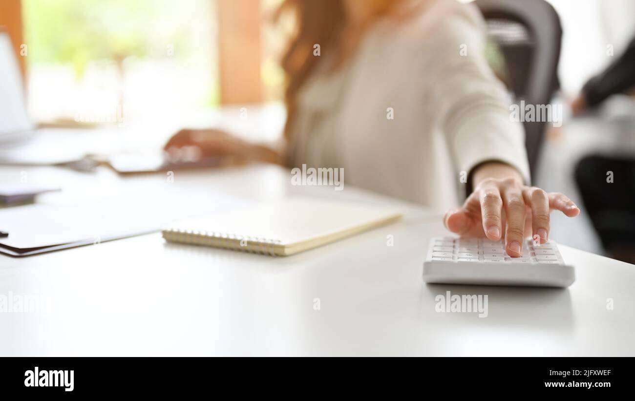 Professional female accountant or businesswoman hand using a calculator ...