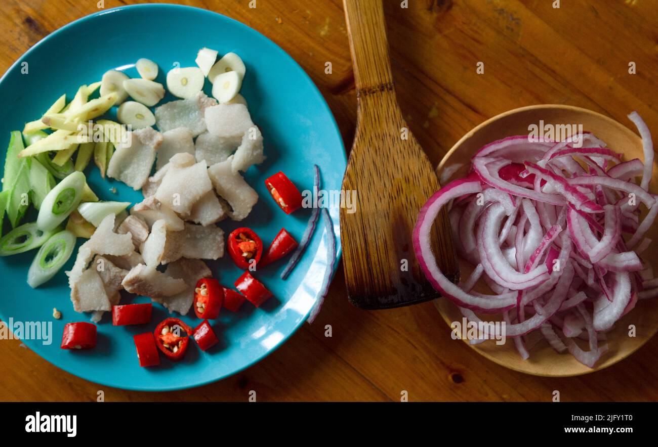 In the blue plate, there is hot water blanched pork, sliced and chopped
