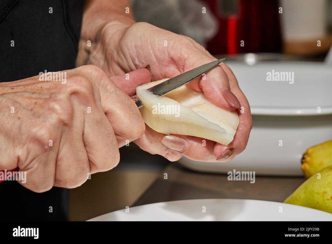 Pear Chef Chef cuts the pears into slices for chocolate cake with pear and nuts ...