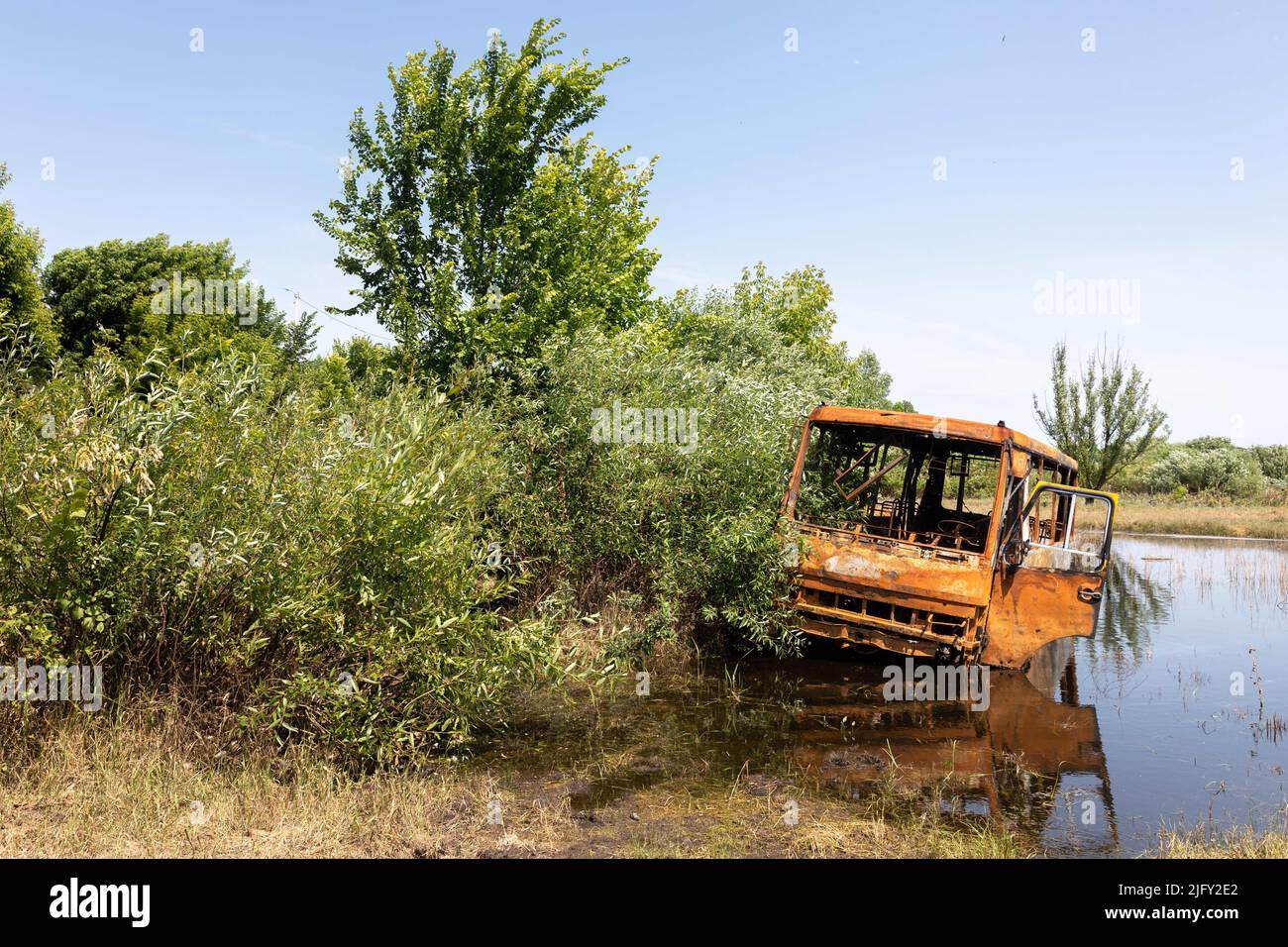 Chernihiv, Ukraine. 19th June, 2022. A burnt-out bus is abandoned in a small lake. Landscapes of Ukraine after the invasion of Russian fascists. (Credit Image: © Mykhaylo Palinchak/SOPA Images via ZUMA Press Wire) Stock Photo