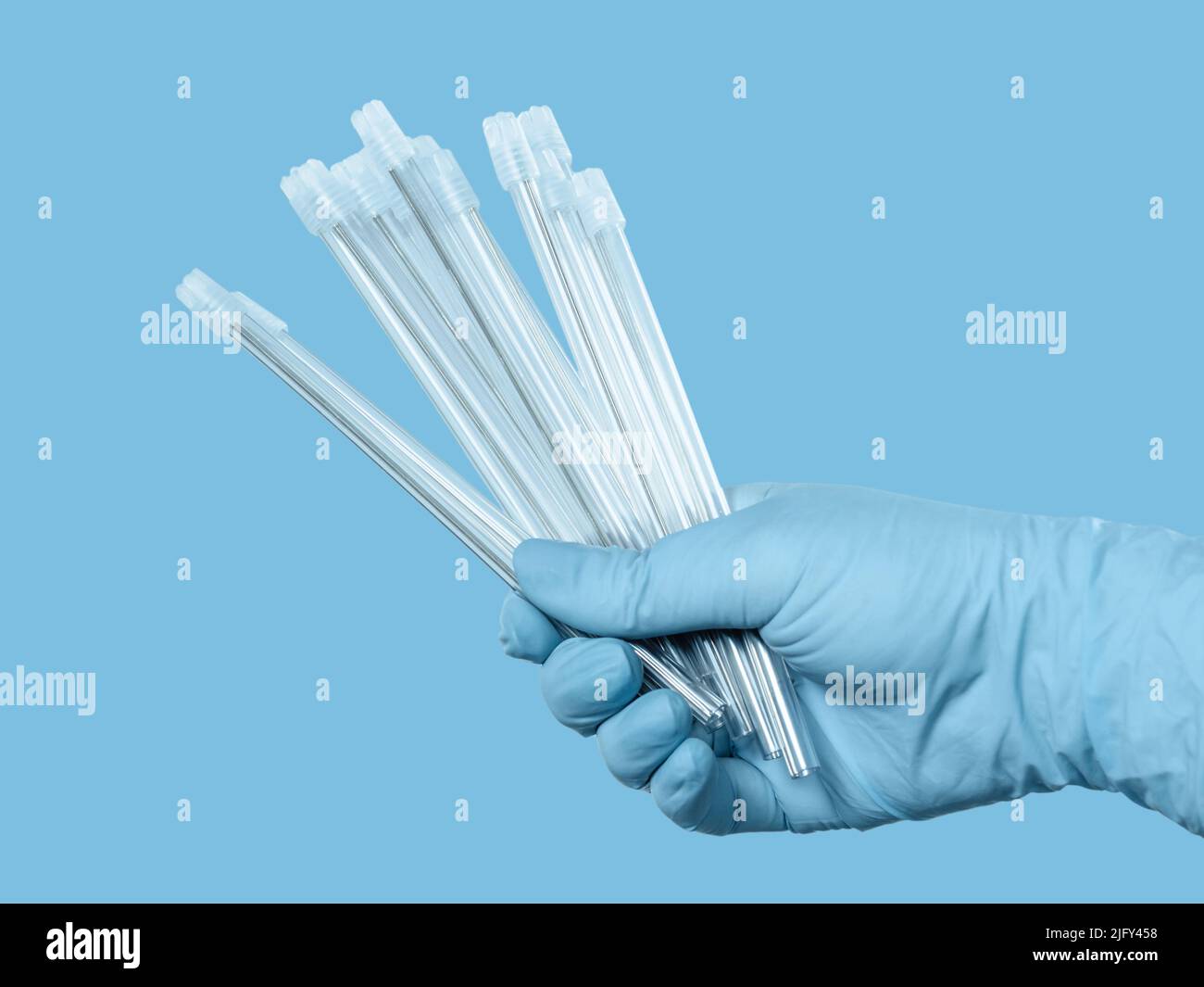 Dentist's hand in a latex glove with saliva ejectors on the blue