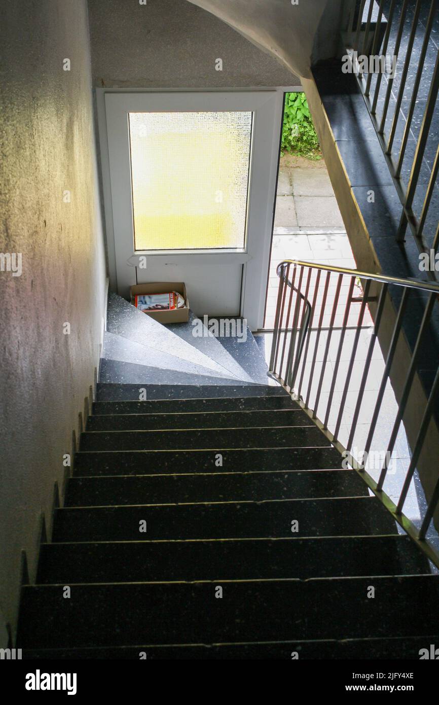 View of entrance of cheap apartment in Itzehoe, Germany with door open and staircase in summer