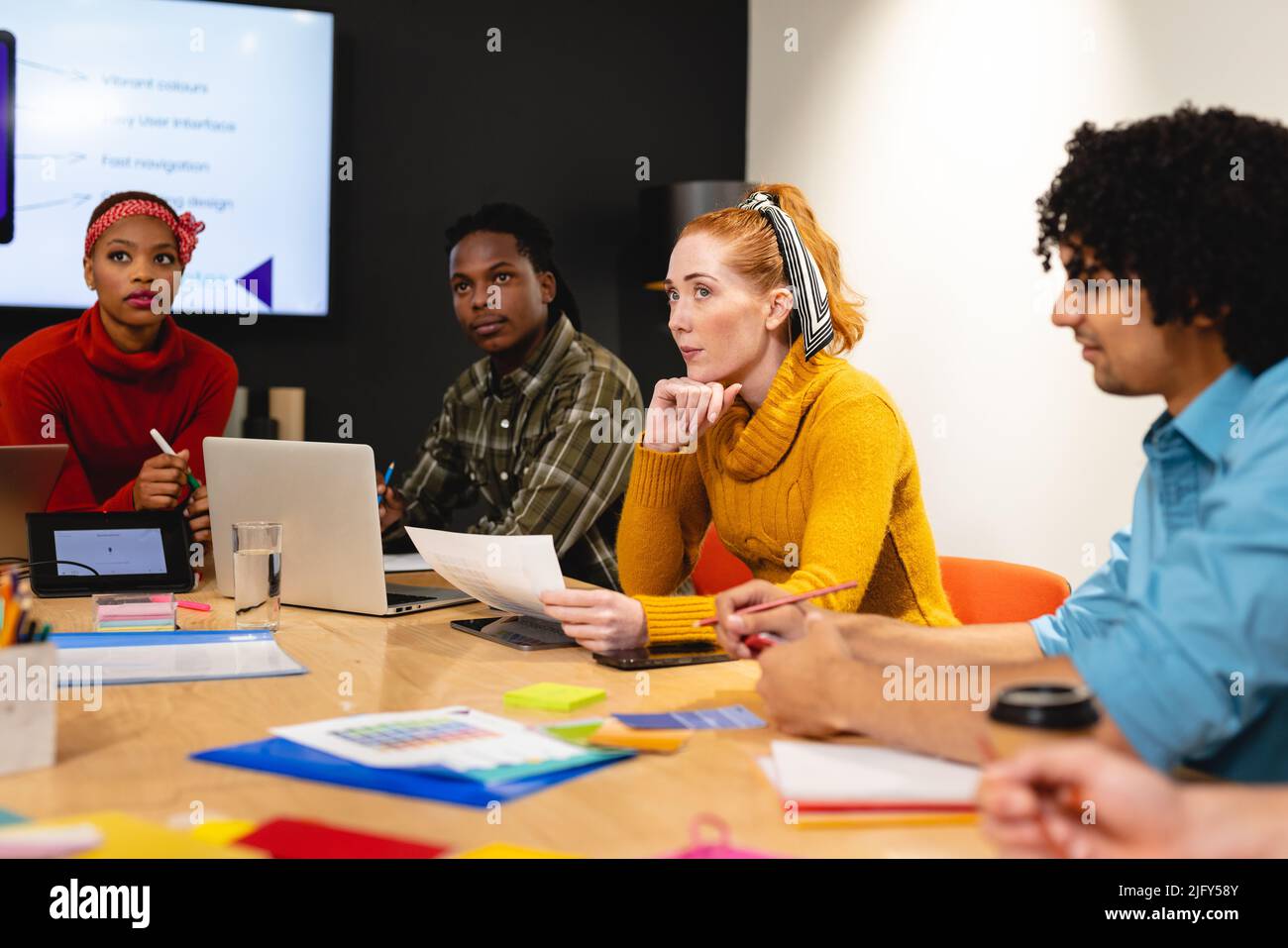 Serious female caucasian app developer with colleagues in board room at office Stock Photo