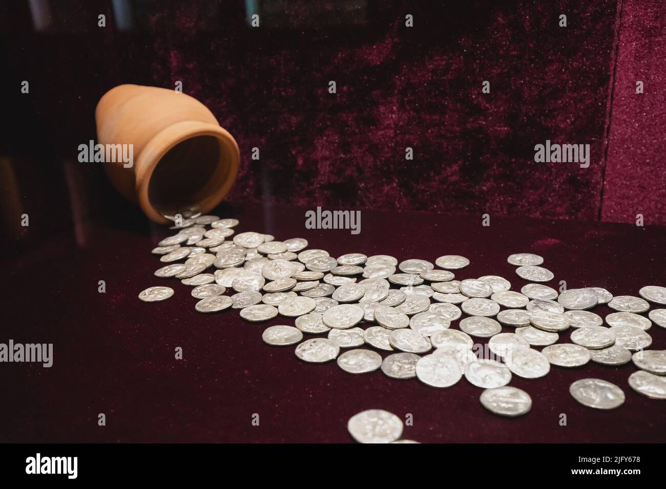 Silver Greek drachma coins scattered from an ancient clay jug Stock Photo