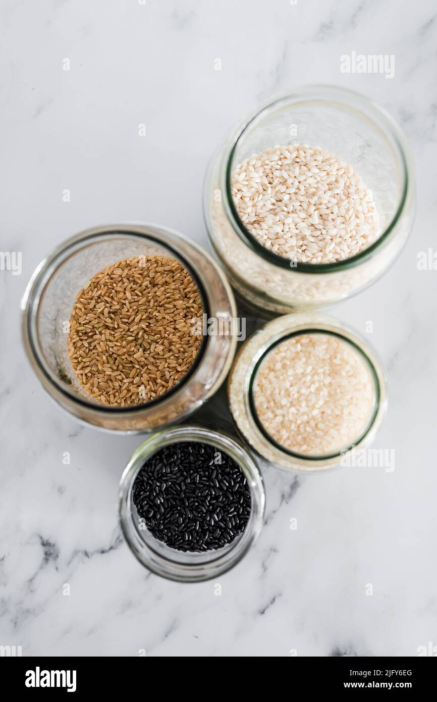 pantry jars with different types of rice including black brown arborio